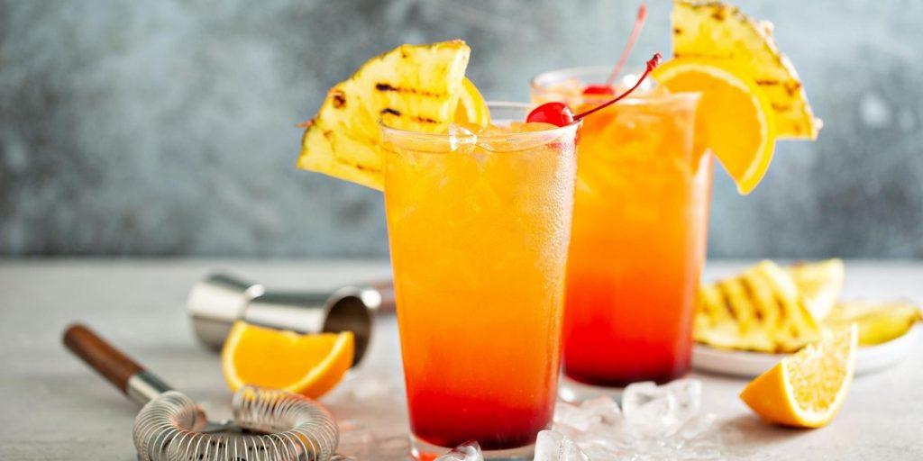 Long Italian Sunrise Cocktail garnised with pineapple and orange