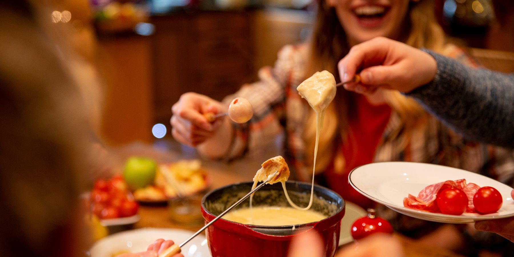 70s fondue party with everyone dipping into the cheese