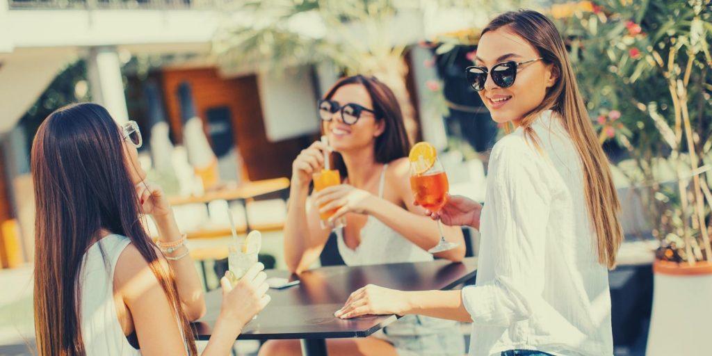 Three friends enjoying low alcohol cocktails in an outside setting