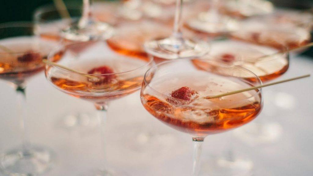 Close up of a series of Champagne Martinis in coupe glasses garnished with fresh berries