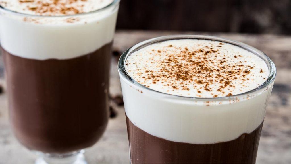 Close of up of two cups of Irish Coffee dusted with cacao 