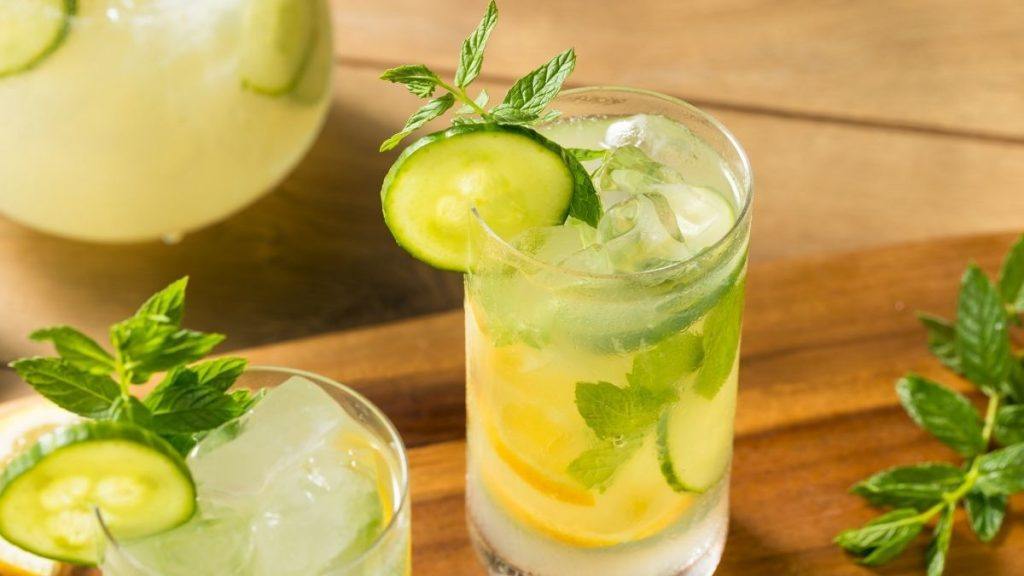 French Maid cocktail in a tall glass on ice garnished with cucumber and fresh mint