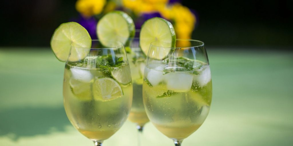 Front view of a trio of Hugo Cocktails garnished with lime wheels