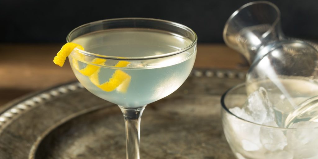 Close up of a 50 50 martini with lemon twist on a silver tray