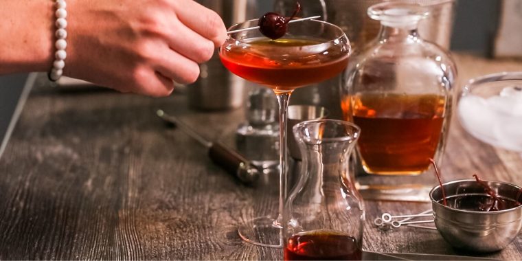 French Manhattan Cocktail with Maraschino cherry garnish on wooden table