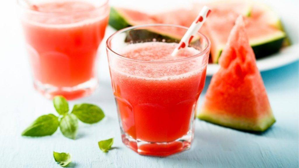 Bourbon and watermelon juice in a tumbler with colorful straw