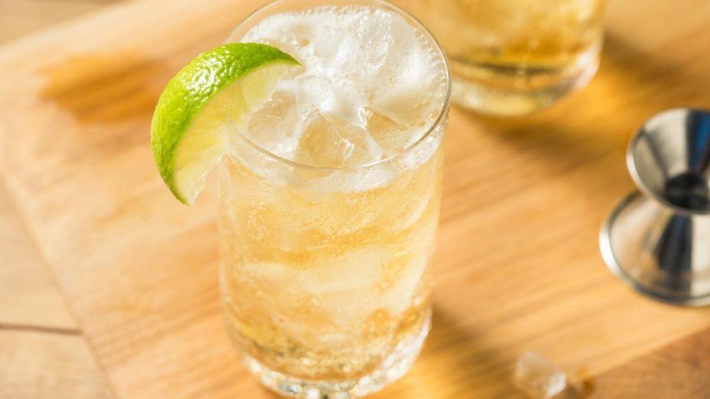 Close up top view of bourbon and ginger ale in a highball glass with ice and lime