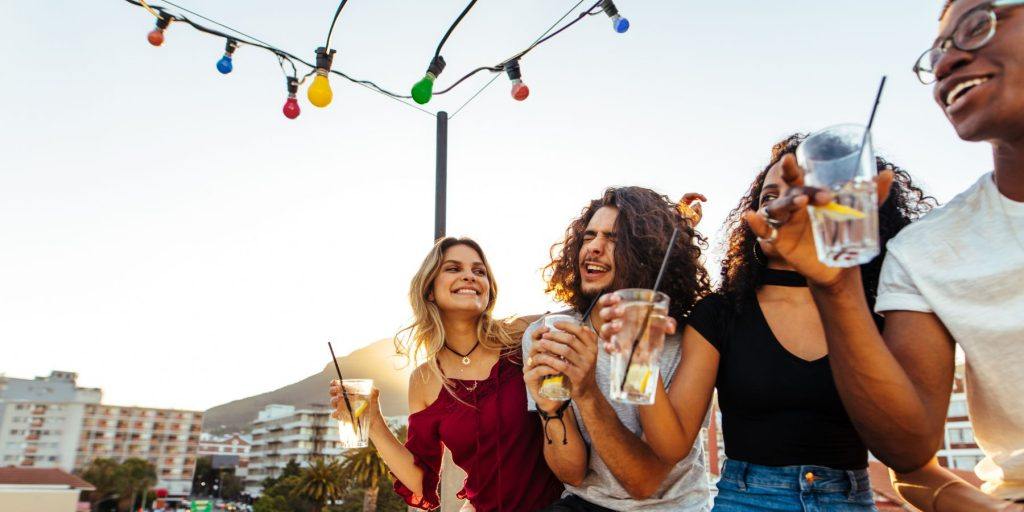 Side view of a group of diverse friends dancing and enjoying music at an outdoor cocktail party