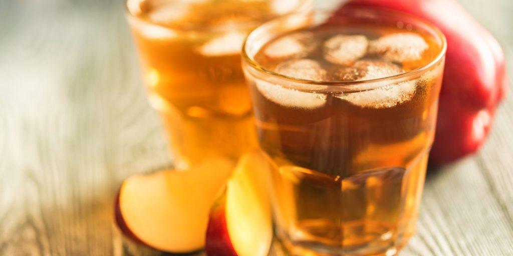 Close up of Bourbon Apple Cider cocktails on the rocks with fresh apple garnish