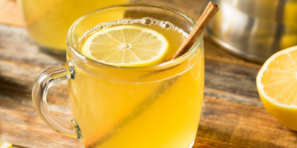 Hot Toddy cocktail in a glas mug with sliced lemon and cinnamon stick