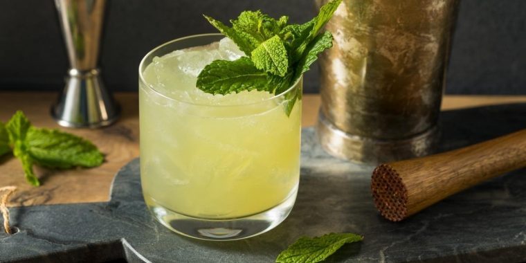 Close-up of Swamp Water Cocktail in rocks glass garnished with fresh mint