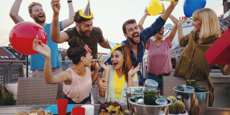 Close-up group shot of a bunch of friends having a great time at a DIY at-home birthday party