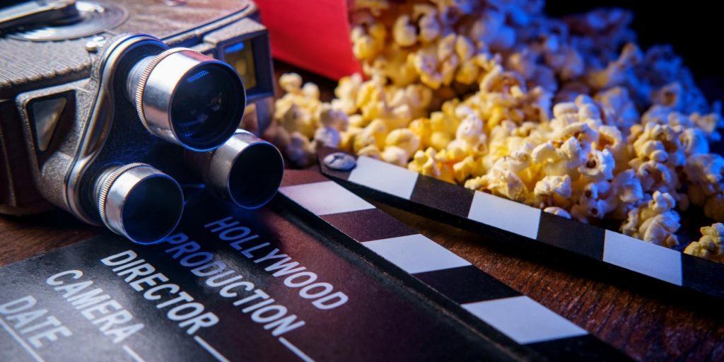 Movie party theme props, including vintage camera, popcorn and clapboard