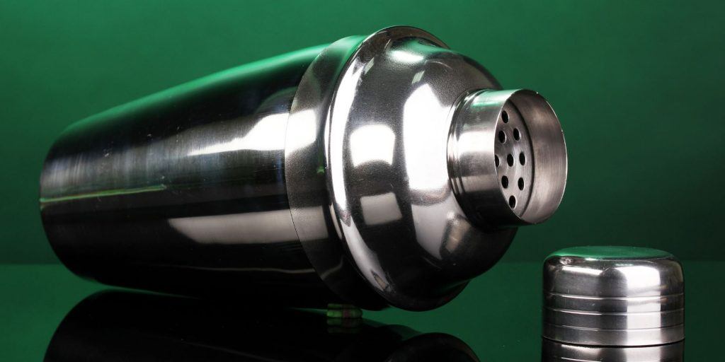 Cocktail shaker on it's sideon a green background