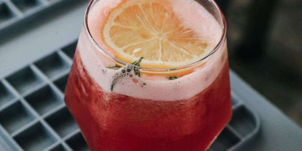 close up of fizzy mocktail with thyme and lemon