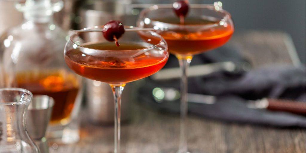 Two classic Manhattan cocktails with maraschino cherry