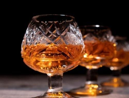 two glasses of cognac in a dark background