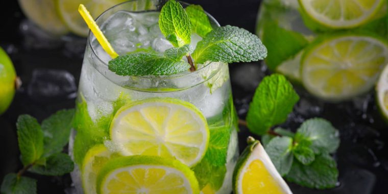 Virgin Mojito with a yellow straw, mint and sliced lime
