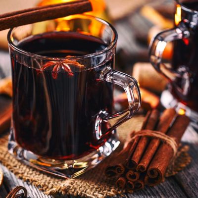 Mugs of mulled wine with cinnamon and orange