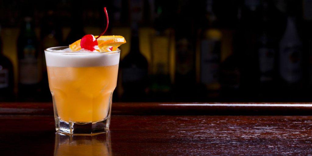 An apple brandy sour on a dark background