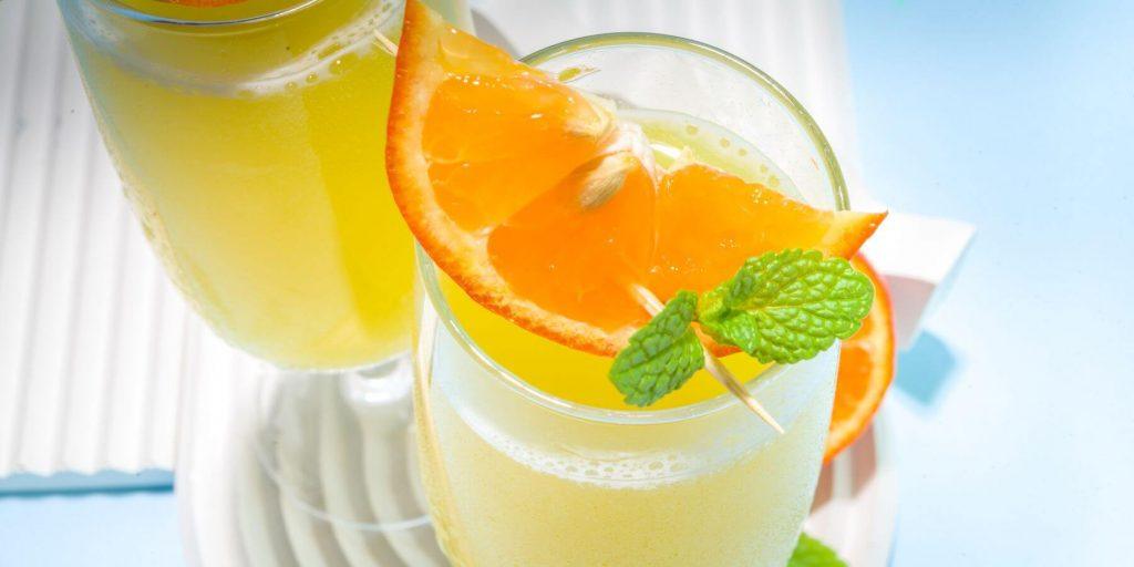 Mimosa mocktails on a sunny day with orange and mint