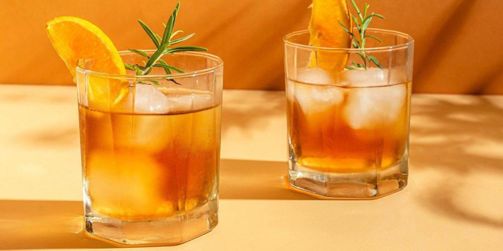 Amber coloured mezcal cocktails with rosemary garnish