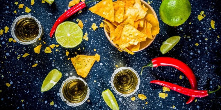 Top shot of mezcal shots and nachos