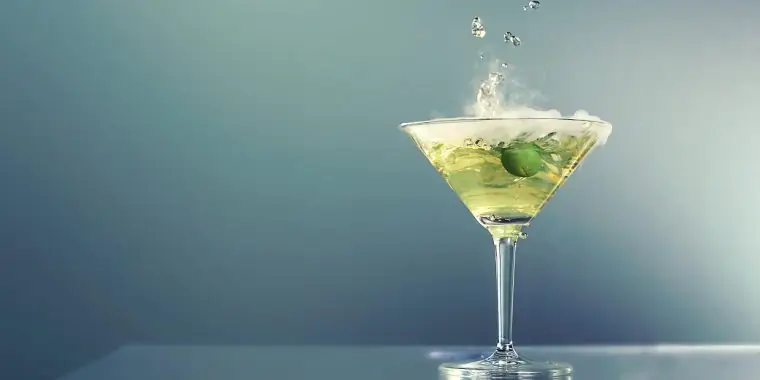Smoking dry ice dirty martini with green olive garnish