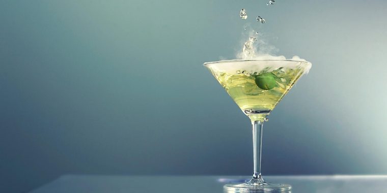 Smoking dry ice dirty martini with green olive garnish