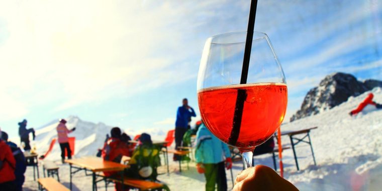 Close-up of an Aperol Spritz against a ski resort backdrop