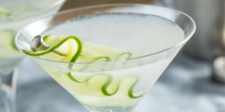 Cucumber martini close up with a sliver or cucumber on a cocktail pick