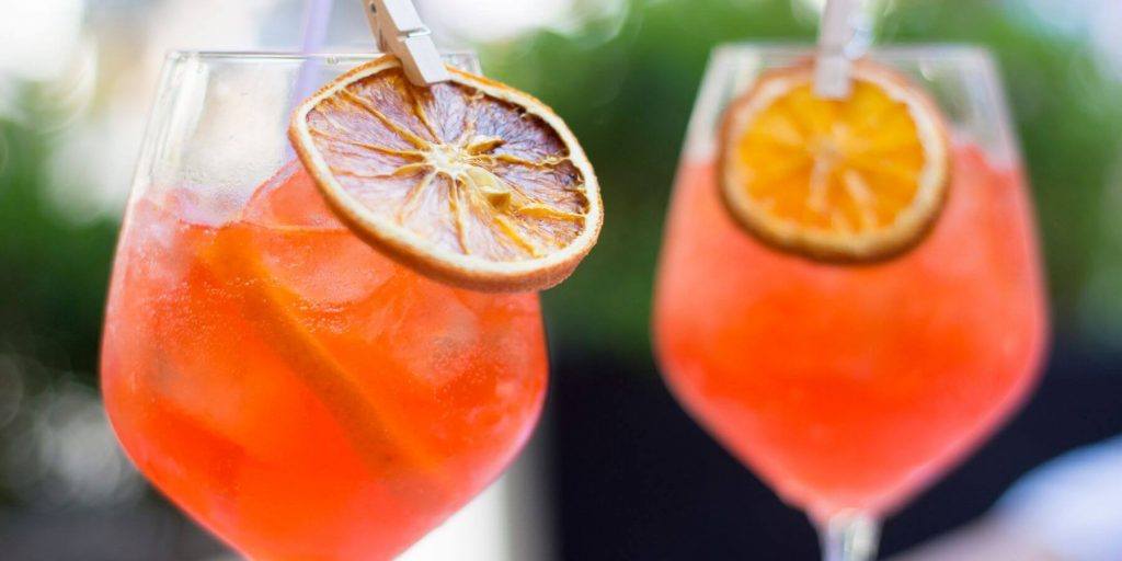 Two Aperol Spritz with beer and a dried orange garnish