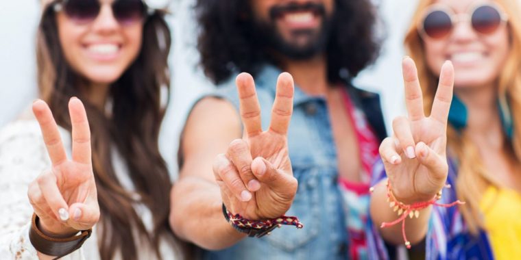 249.US 60s Theme Party Canva MACg7 o5dvY happy young hippie friends showing peace 1480x740 1