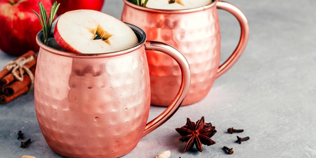 Apple Cider Mule cocktails with sliced apple, cinnamon and star anise garnish