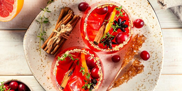 Sweet cranberry cocktails with sugared rim and cinnamon garnish