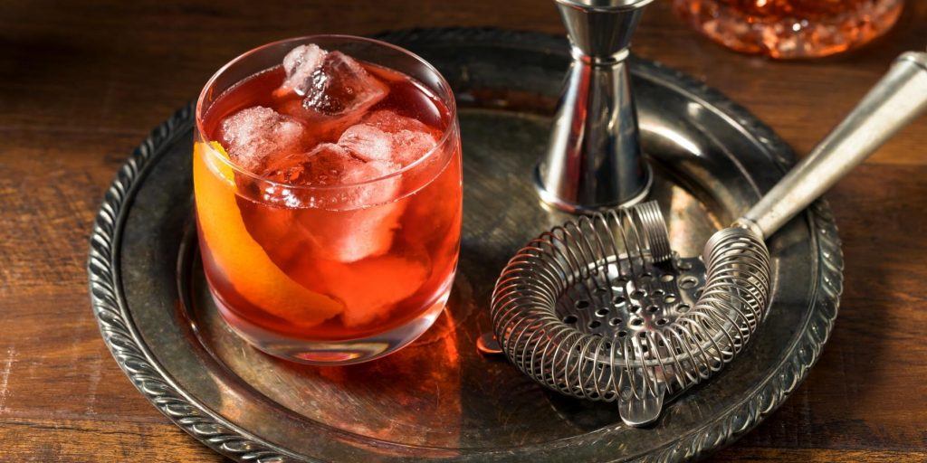 The classic Aperol Americano cocktail, a refreshing mix of Aperol, sweet vermouth, and soda, served over ice.
