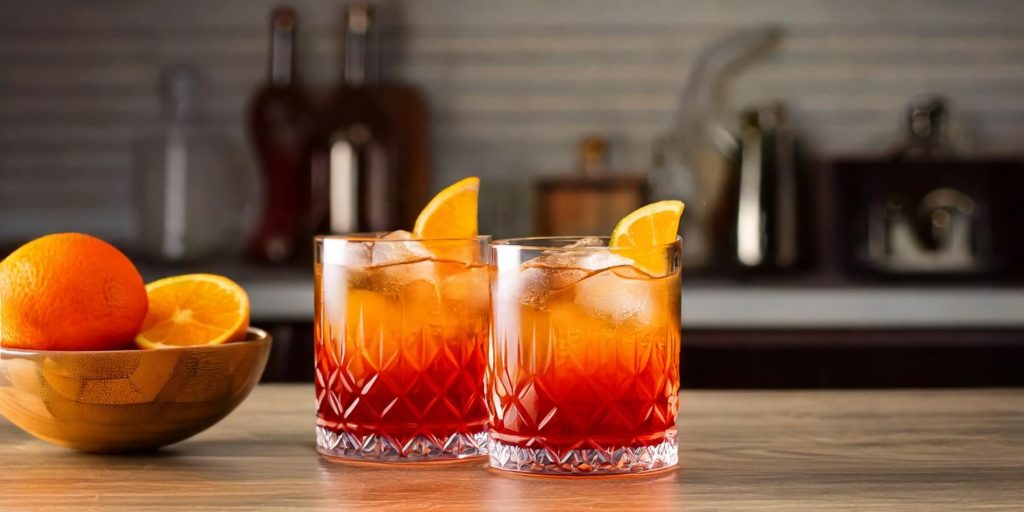 Two Aperol Boulevardier cocktails served in a modern kitchen setting