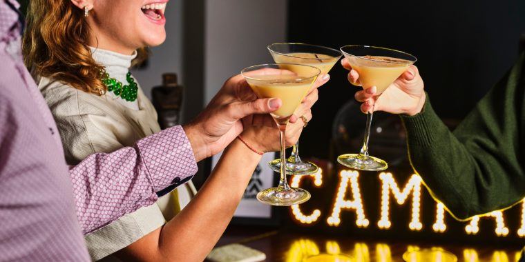 Friends enjoying clinking eggnog martinis togeher