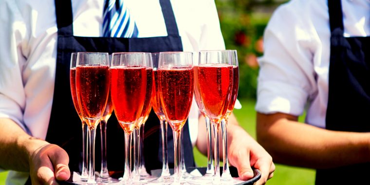 Waiter serving red wedding cocktails