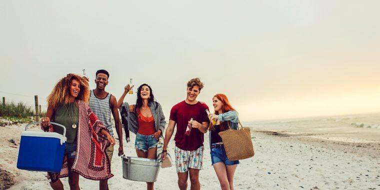 Friends carrying cooler boxes to a BYOB party