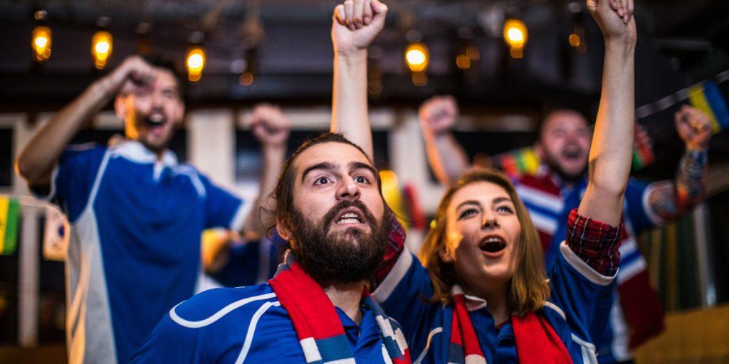 Soccer fans cheering while watching TV