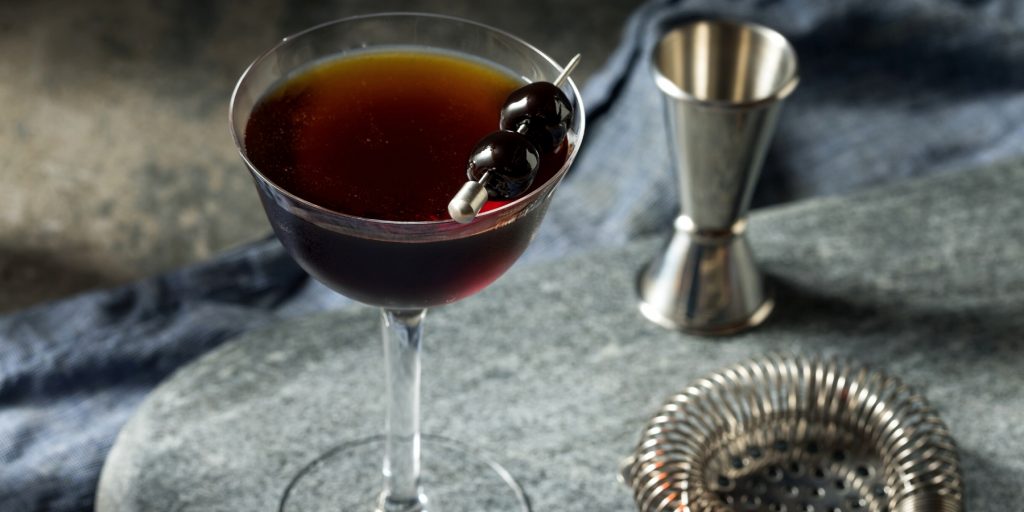 A Black Manhattan cocktail garnished with a cherry