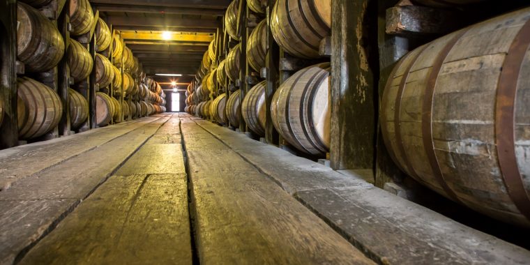 A bourbon barrel aging room lined with barrels