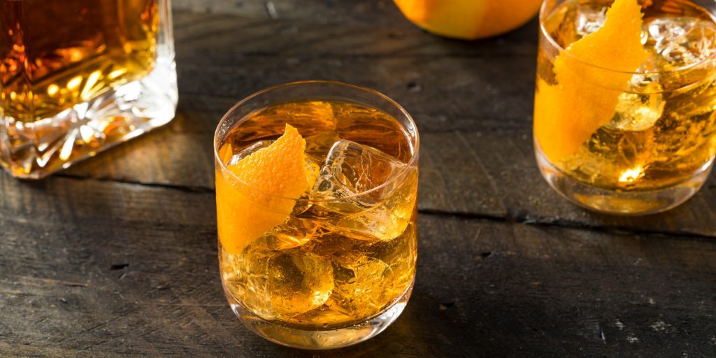 Two bourbon cocktails garnished with orange twist
