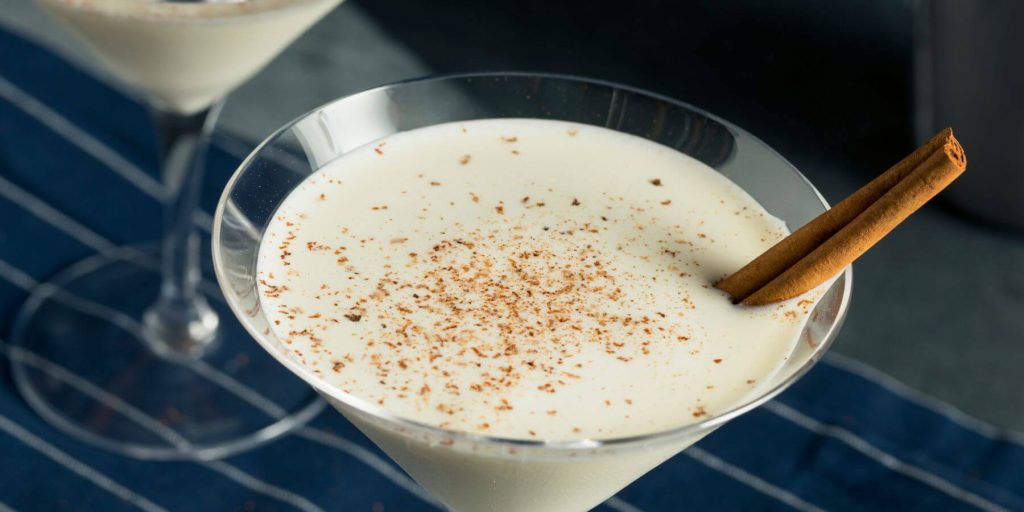 Creamy vegan Eggnog Martini sprinkled with cinnamon