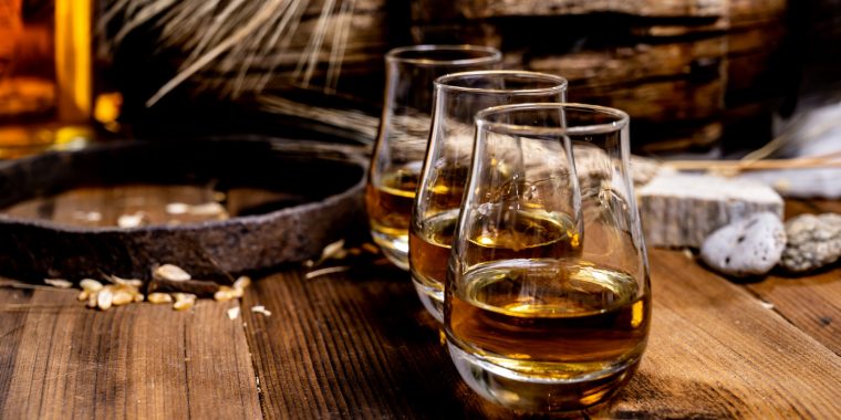 Three glasses on Scotch on a wooden table