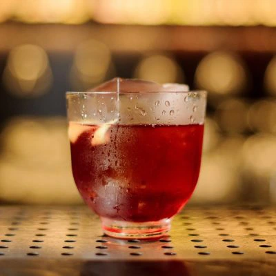 A Vieux Carre cocktail on a bar counter garnished with a lemon twist