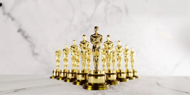 A series of Academy Awards Oscars statues standing in formation against a white marble backdrop