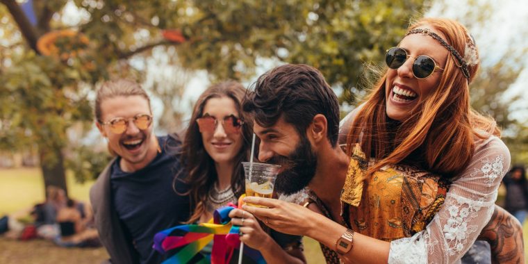 Friends laughing and enjoying camping cocktails at a music festival