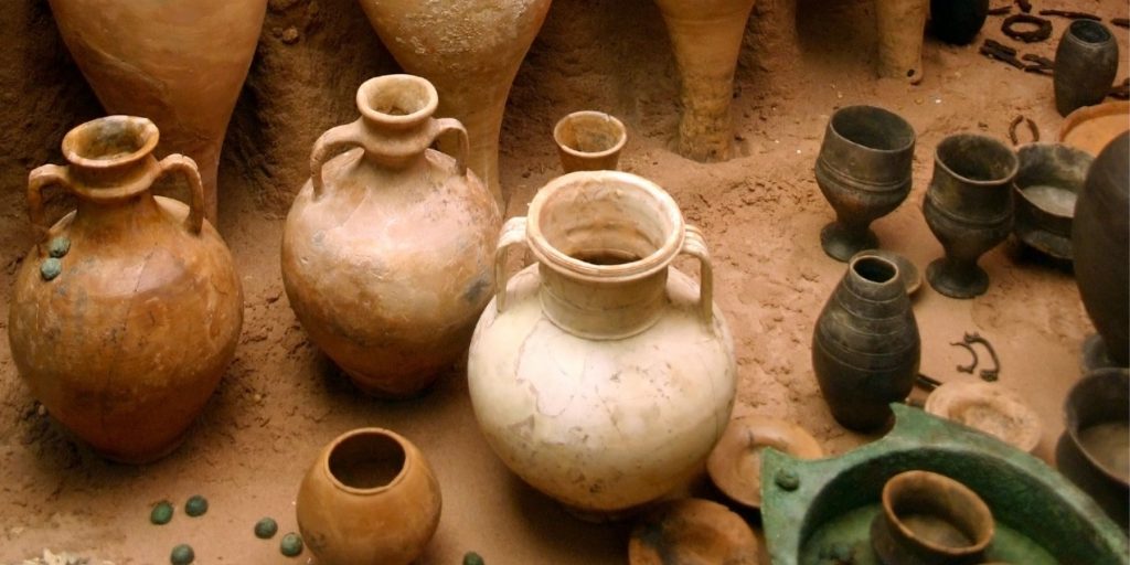 Top view of a collection of historic alcohol containers, including tankards and amphora